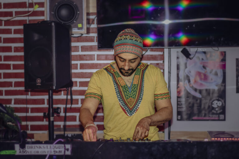 Ahmed står vid ett mixer bord och dj:ar.