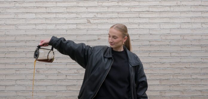Annika häller ut kaffet från en kaffekanna.