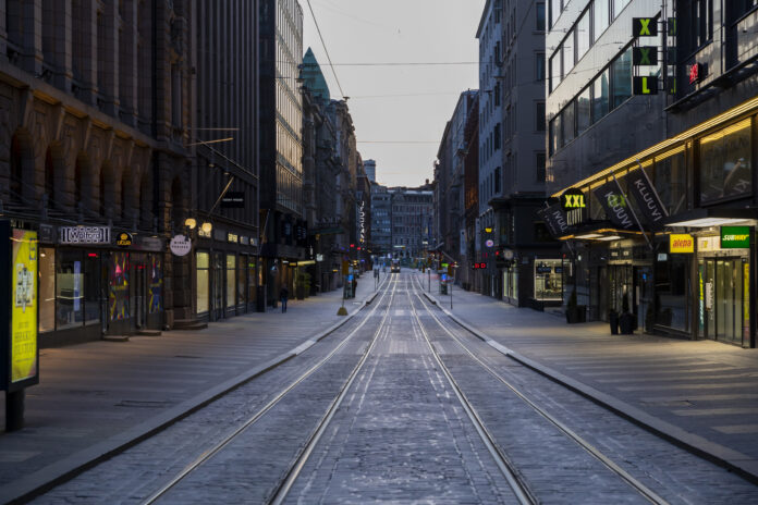 En rak tom gata i en stad i skymmningen.